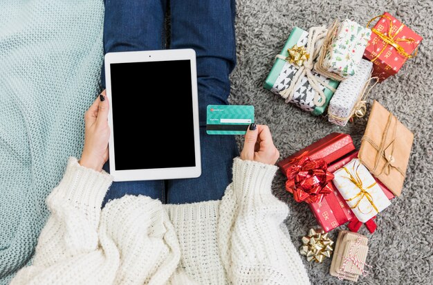 Frau mit Geschenken und Kreditkarte mit Tablette