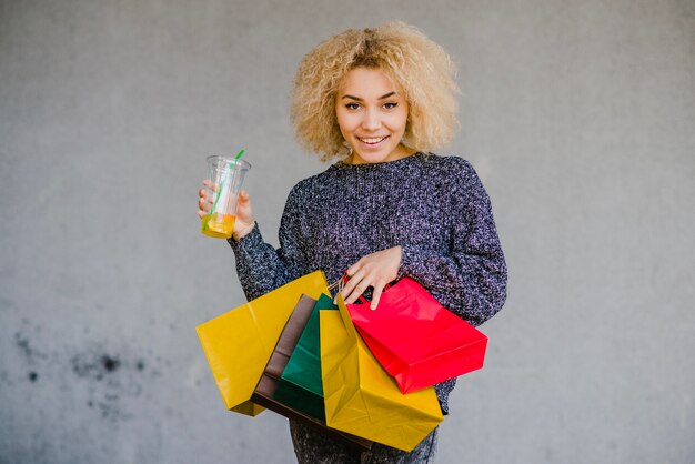 Frau mit Getränk und Papiertüten