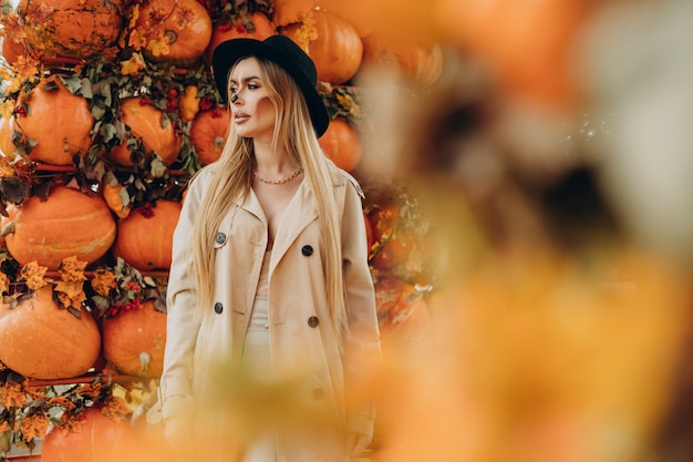 Kostenloses Foto frau mit halloween-make-up steht bei halloween-kürbissen