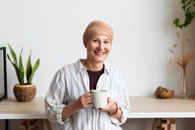 Frau mit Hautkrebs, die eine Tasse hält