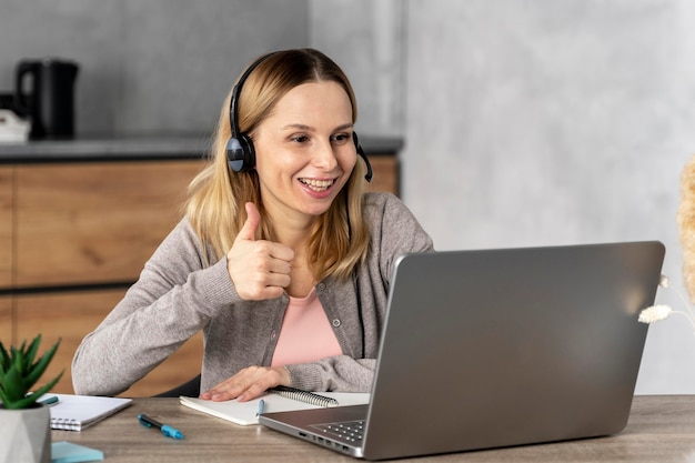 Frau mit Headset arbeitet am Laptop