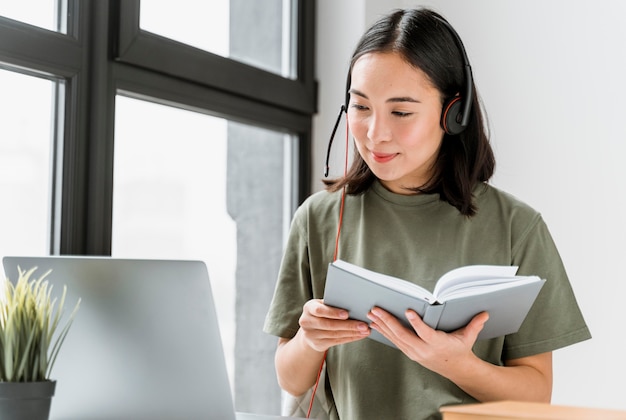 Frau mit Headset, die Videoanruf auf Laptop hat