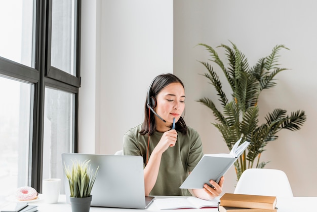 Frau mit Headset, die Videoanruf auf Laptop hat