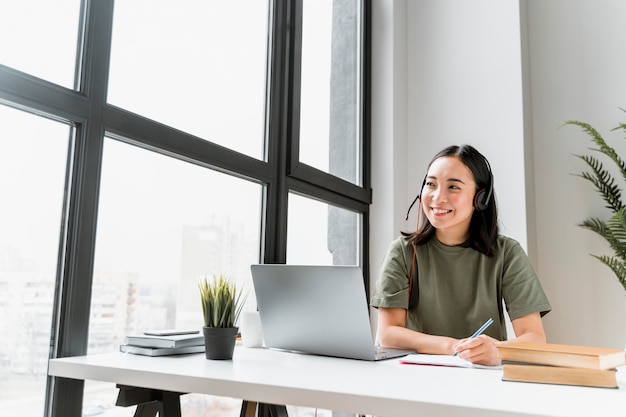 Frau mit Headset, die Videoanruf auf Laptop hat