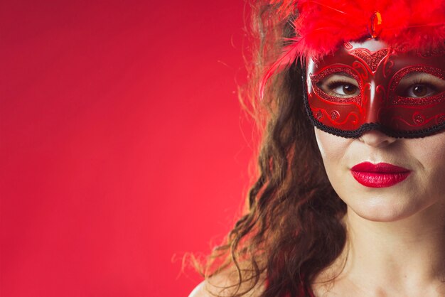 Frau mit hellem Make-up und roter Maske