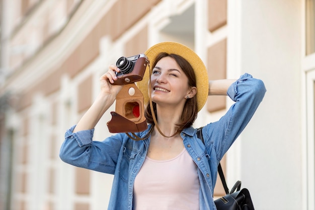 Frau mit Hut, die im Urlaub Fotos macht