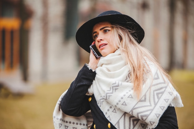 Frau mit Hut und Schal reden am Telefon