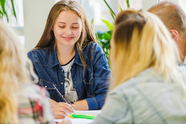 Frau mit Klassenkameraden, die das Studium genießen