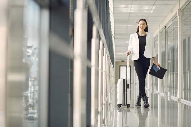 Frau mit Koffer am Flughafen