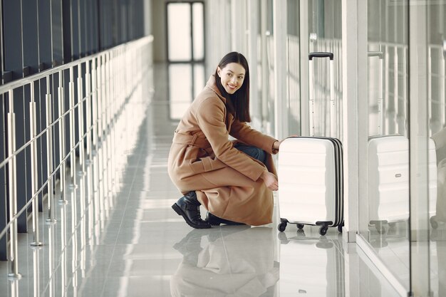 Frau mit Koffer am Flughafen