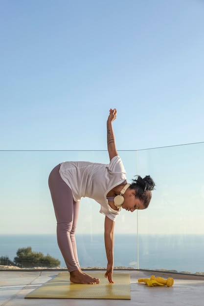 Frau mit Kopfhörern, die Fitness zu Hause tun