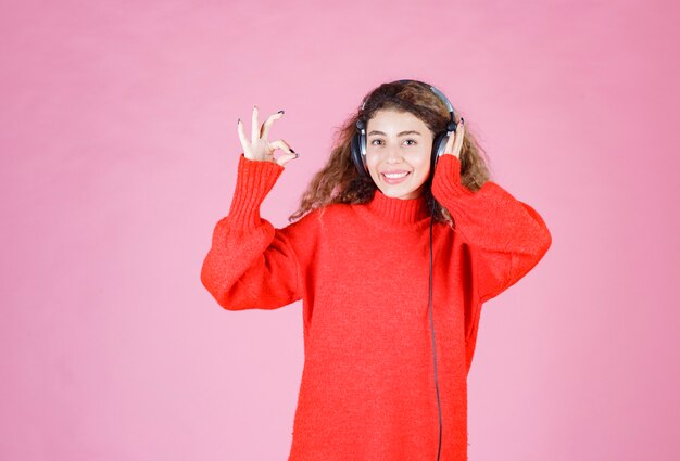 Frau mit Kopfhörern hört und genießt die Musik.