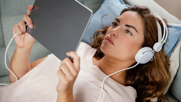 Frau mit Kopfhörern mit Tablette