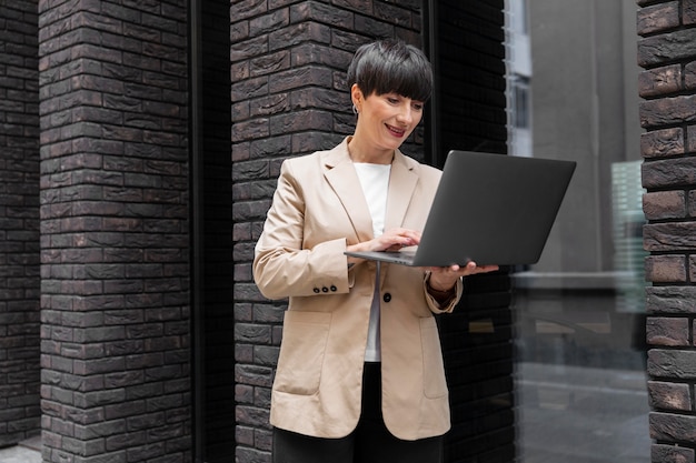 Frau mit kurzen Haaren, die ihren Laptop überprüft