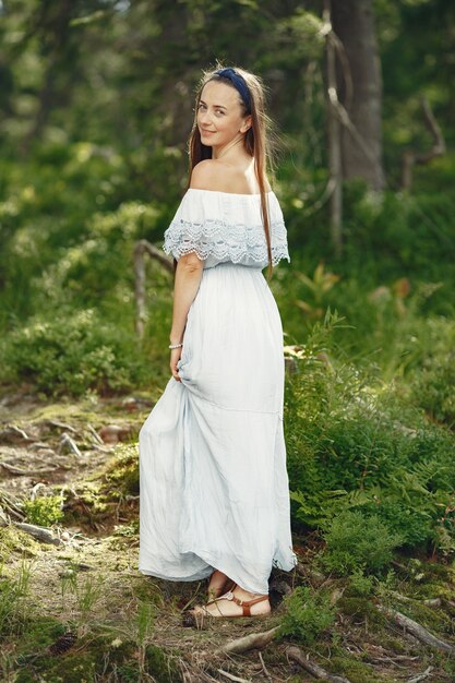 Frau mit langen Haaren. Dame in einem blauen Kleid. Mädchen mit unberührter Natur.