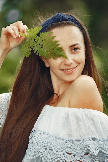 Kostenloses Foto frau mit langen haaren. dame in einem blauen kleid. mädchen mit unberührter natur.