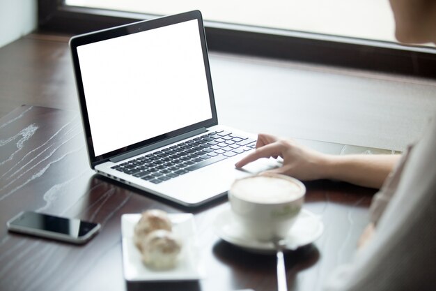 Frau mit Laptop auf einem Holztisch