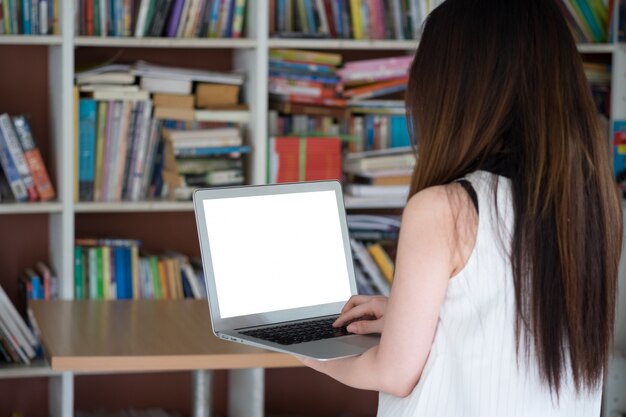 Frau mit Laptop in der Bibliothek