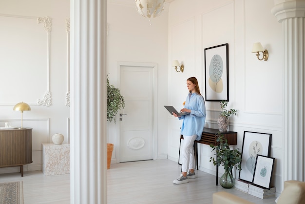 Kostenloses Foto frau mit laptop in minimal eingerichtetem raum