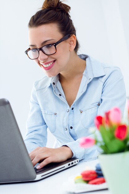 Frau mit Laptop zu Hause arbeiten