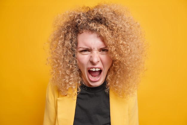 Kostenloses Foto frau mit lockigem, buschigem haar schreit wütend hat streit drückt negative emotionen aus trägt formelle kleidung