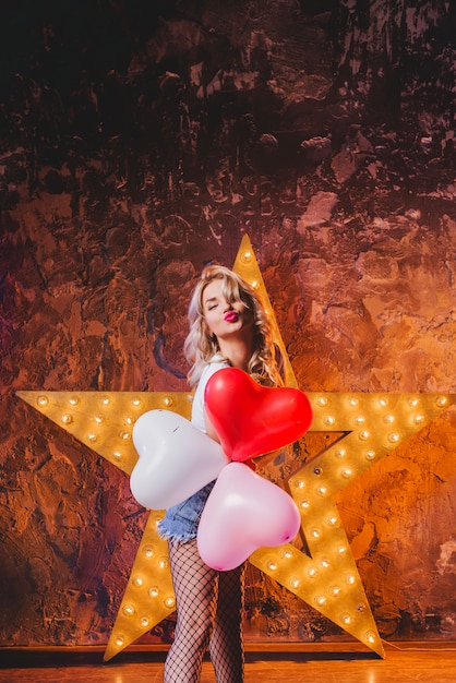 Kostenloses Foto frau mit luftballons senden luft kuss