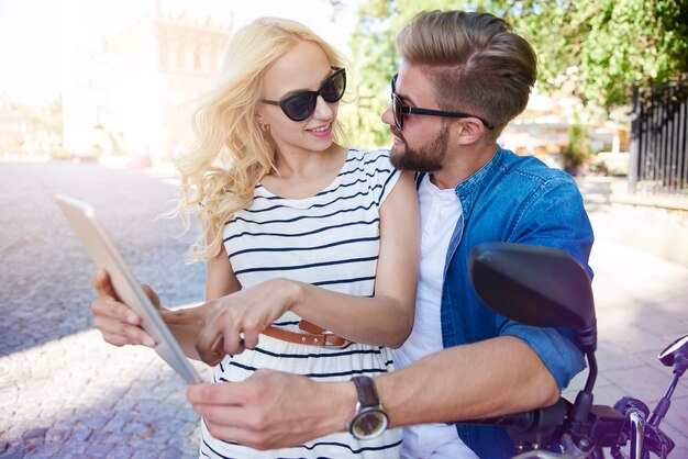 Frau mit Mann, der digitales Tablett an der Stadtstraße verwendet