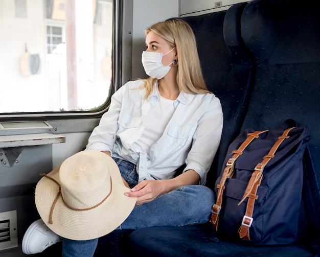 Kostenloses Foto frau mit maske im zug