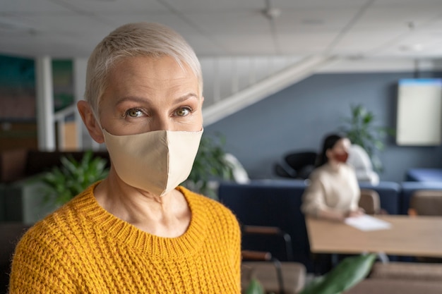 Frau mit medizinischer Maske bei der Arbeit