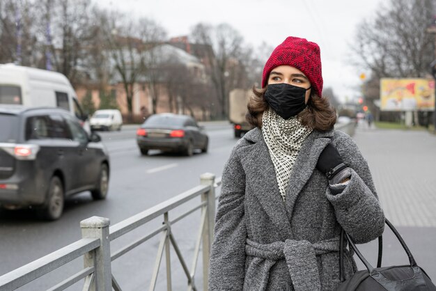 Frau mit medizinischer Maske draußen in der Stadt