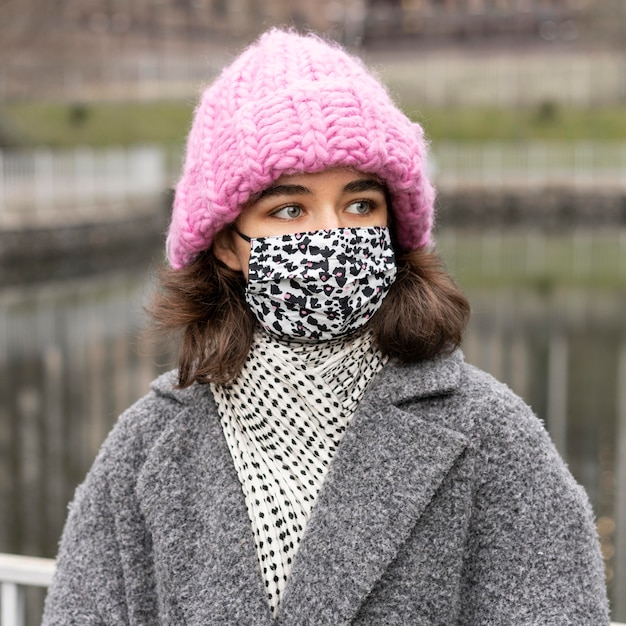 Kostenloses Foto frau mit medizinischer maske im stadtpark