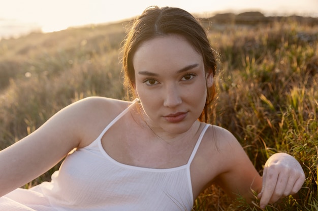 Kostenloses Foto frau mit mittlerem schuss, die auf gras liegt