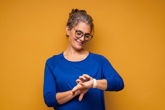 Frau mit mittlerem Schuss, die auf ihre Uhr schaut