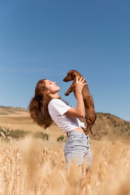 Frau mit mittlerem Schuss, die einen süßen Hund hält