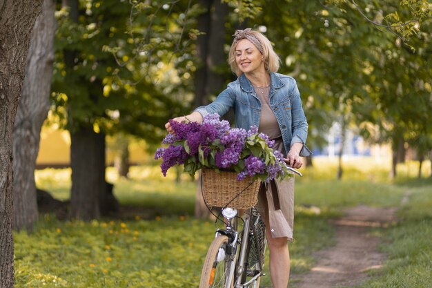 Frau mit mittlerem Schuss, die Fahrrad fährt