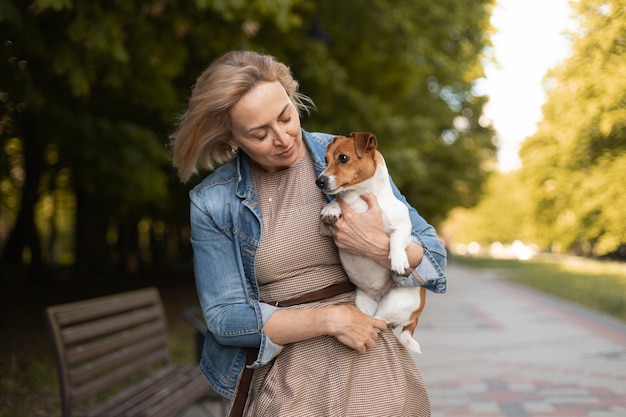 Frau mit mittlerem Schuss, die Hund hält