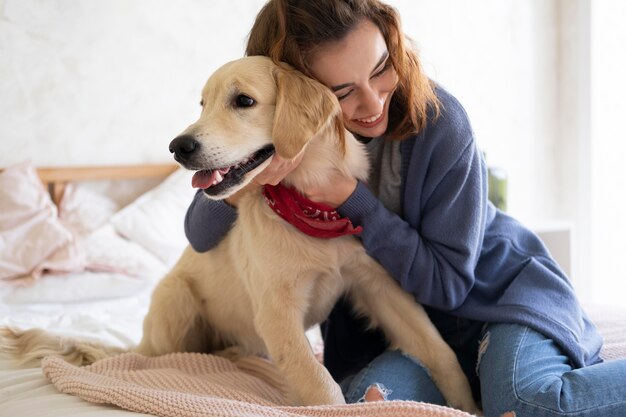 Frau mit mittlerem Schuss, die Hund hält