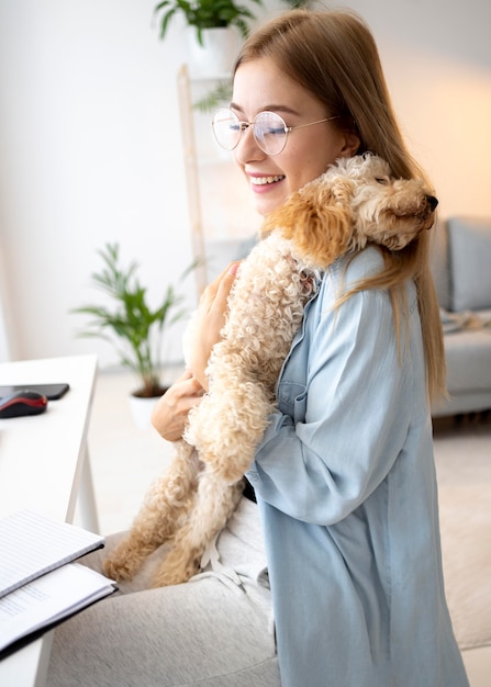 Frau mit mittlerem Schuss, die Hund hält