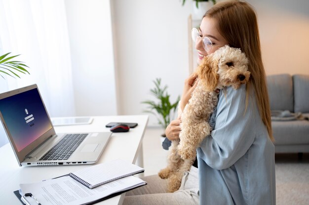 Frau mit mittlerem Schuss, die Hund hält