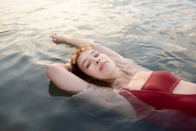 Frau mit mittlerem Schuss, die im Urlaub schwimmt