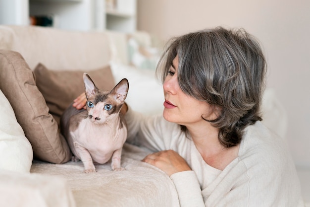 Frau mit mittlerem Schuss, die Katze anschaut