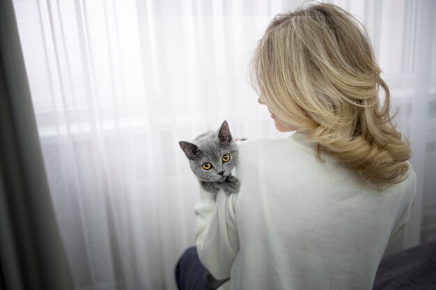 Frau mit mittlerem Schuss, die Katze hält