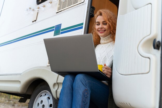 Frau mit mittlerem Schuss, die Laptop hält