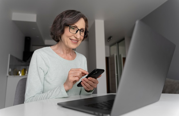 Frau mit mittlerem Schuss, die Smartphone hält