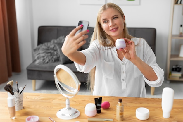 Frau mit mittlerem Schuss, die Smartphone hält