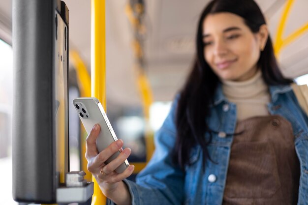 Frau mit mittlerem Schuss, die Telefon hält