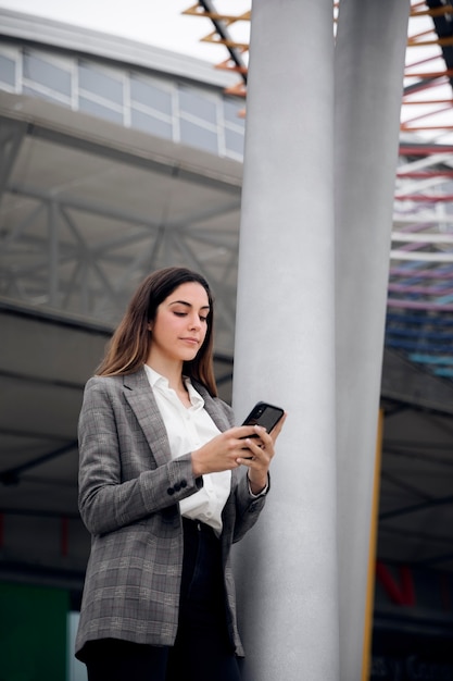 Frau mit mittlerem Schuss, die Telefon hält