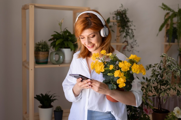 Frau mit mittlerem Schuss, die Telefon hält