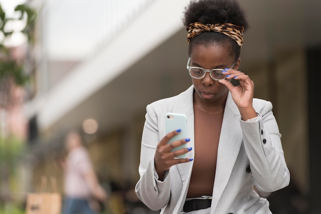 Kostenloses Foto frau mit mittlerem schuss, die telefon hält