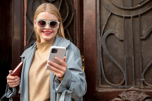 Frau mit mittlerer Aufnahme, die auf das Telefon schaut